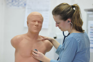 Studentin Merle Winkelmann übt das Abhören des Brustkorbs. Aus dem Innern des Modells sind realistische Herztöne zu hören. (Bild: Uni-Klinikum Erlangen)