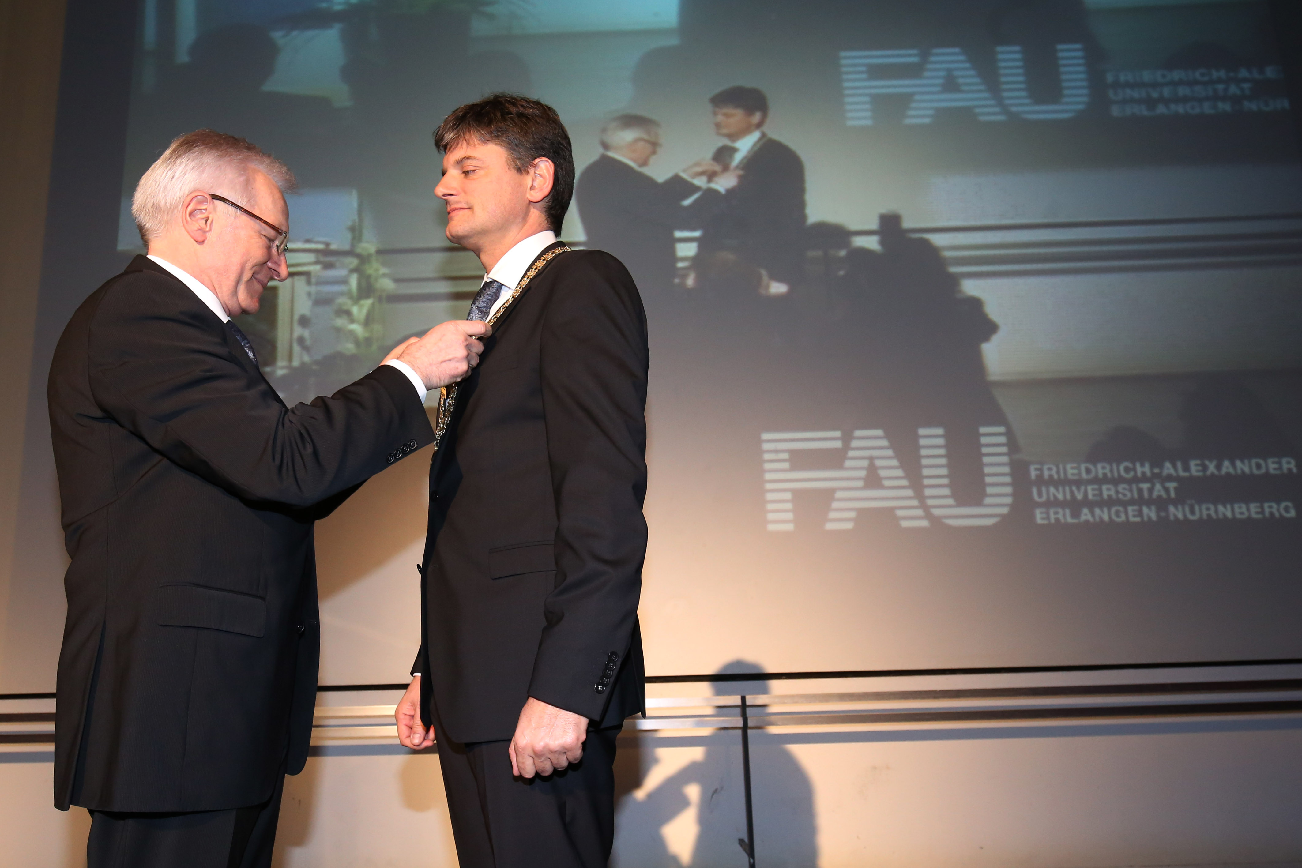 Mit der Übergabe der Amtskette - des wichtigsten der Insignien des Präsidenten der FAU - von Grüske an Hornegger war der Amtswechsel vollzogen. (Bild: FAU/Kurt Fuchs)