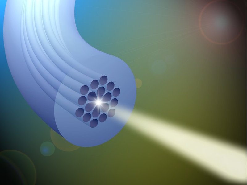 Brillante Quelle für weißes Licht: Eine photonische Kristallfaser haben Erlanger Max-Planck-Forscher so maßgeschneidert, dass sie aus einem infraroten Laserpuls Licht mit einem besonders breiten Spektrum erzeugen können. Dabei kommt es entscheidend darauf an, wie sich die hohlen Kanäle, die sich durch die Glasfaser ziehen, um den Faserkern anordnen. (Bild: Xin Jiang)