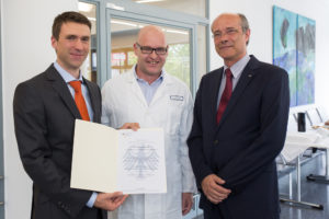 Stefan Müller, Parlamentarischer Staatssekretär BMBF, Prof. Dr. Georg Schett, Direktor der Medizinischen Klinik 3 und Sprecher des METARTHROS-Verbunds, Prof. Dr. Günter Leugering, Vizepräsident für Internationales der FAU, bei der Übergabe des Bewilligungsbescheides. (Bild: FAU/Erich Malter)