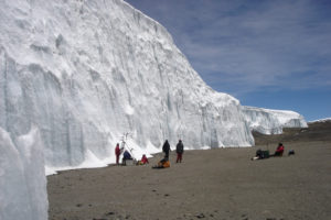 Installation einer automatischen Wetterstation vor dem Eiskliff des Nördlichen Eisfeldes am Kilimandscharo auf 5.700 m Höhe. (Bild: Thomas Mölg)