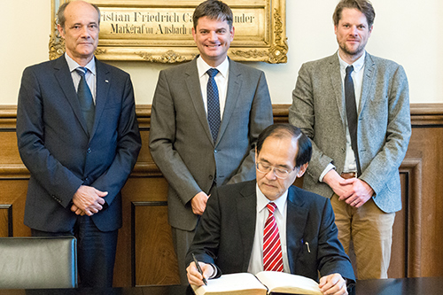 Der Generalkonsul Hidenao Yanagi (vorn) beim Eintrag ins Goldene Buch der FAU, mit dabei: FAU-Vizepräsident Prof. Dr. Günter Leugering, FAU-Präsident Prof. Dr. Joachim Hornegger und Prof. Dr. Fabian Schäfer vom Lehrstuhl für Japanologie. (Bild: Franziska Sponsel)