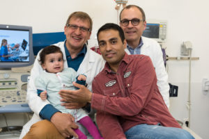 Prof. Dr. Sven Dittrich (back left) and Prof. Dr. Robert Cesnjevar (back right) treated and operated on the little girl after she was admitted to hospital with a severe heart defect. Raghad's father is incredibly grateful for the life-saving support she received in Erlangen. (Image: Universitätsklinikum Erlangen)