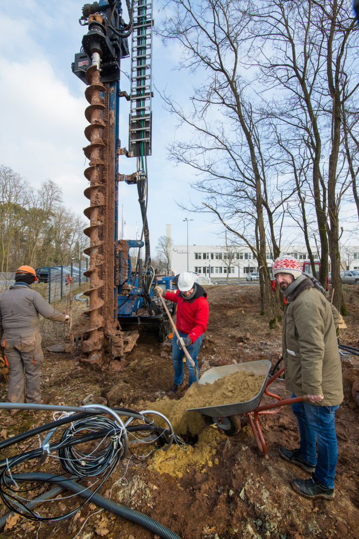 Dr. David Bertermann vom Geozentrum Nordbayern und Leiter des Projektes hilft ebenfalls mit und füllte schubkarrenweise Verfüllmaterial in eines der Bohrlöcher (Bild: FAU/Erich Malter)