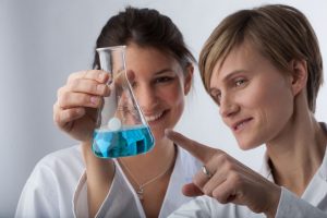 Wissenschaftlerinnen und Wissenschaftler sitzen gemeinsam an einem Tisch und mehreren Laptops.