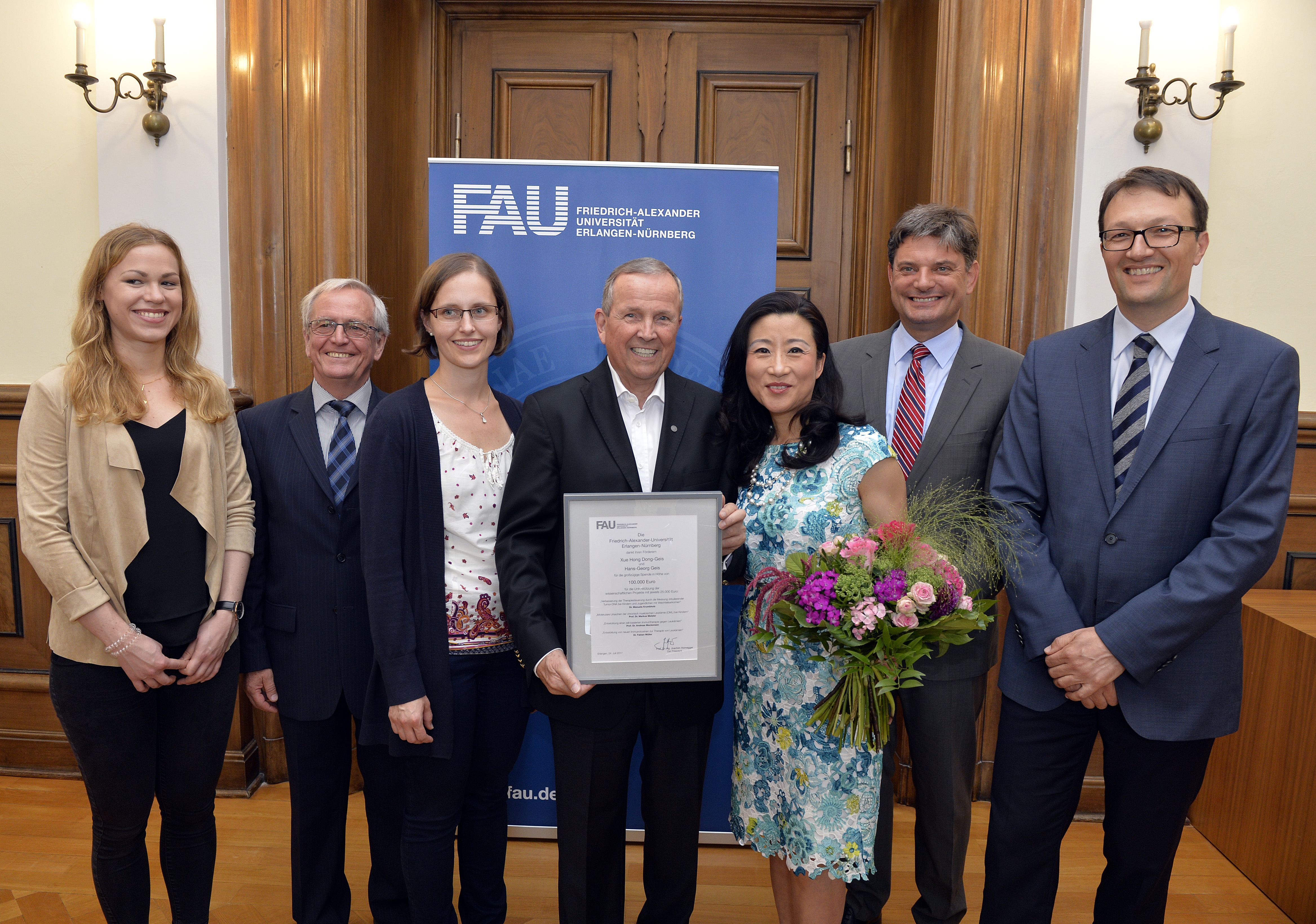 Der Unternehmer Hans-Georg Geis und seine Frau Xue Hong Dong-Geis fördern die Krebsforschung an der FAU mit einer Spende von 100.000 Euro für vier Projekte. Alle Beteiligten kamen zur Übergabe der Förderurkunde ins Amtszimmer des FAU-Präsidenten Joachim Hornegger. Foto (v.li): Verena Mahr, Prof. Wolfgang Rascher, Sabine Semper, Hans-Georg Geis, Xue Hong Dong-Geis und Joachim Hornegger, Prof. Markus Metzler. (Foto:FAU/Harald Sippel)