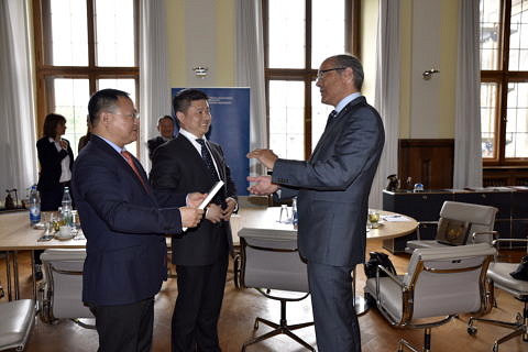 Prof. Dr. Günter Leugering, Vizepräsident für Forschung, übergibt dem Präsidenten der Chonqing University of Posts and Telecommunications (CQUPT) Gastgeschenke. (Bild: FAU/Rebecca Kleine Möllhoff)