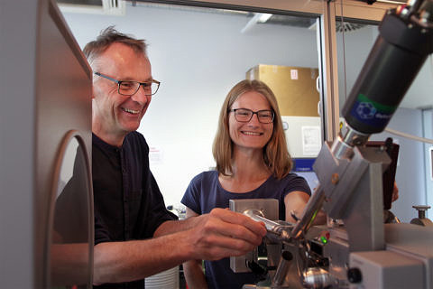 Die FAU-Wissenschaftler Prof. Dr. Yves Muller und Karin Schmidt am Mirkroskop