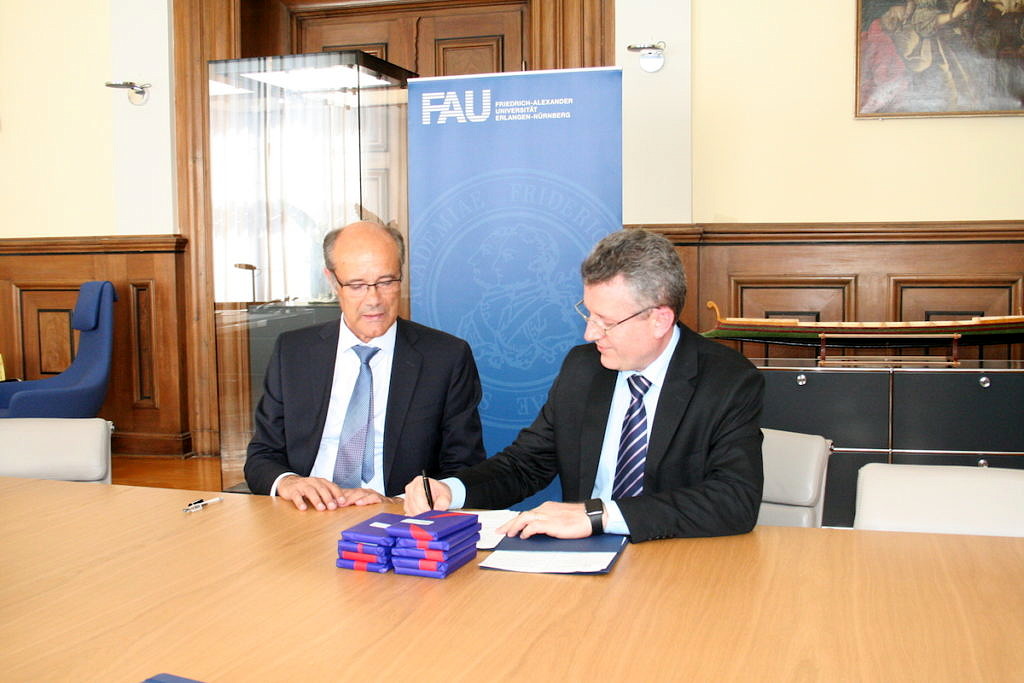 Prof. Dr. Günter Leugering and Odir Antônio Dellagostin sign the contract.