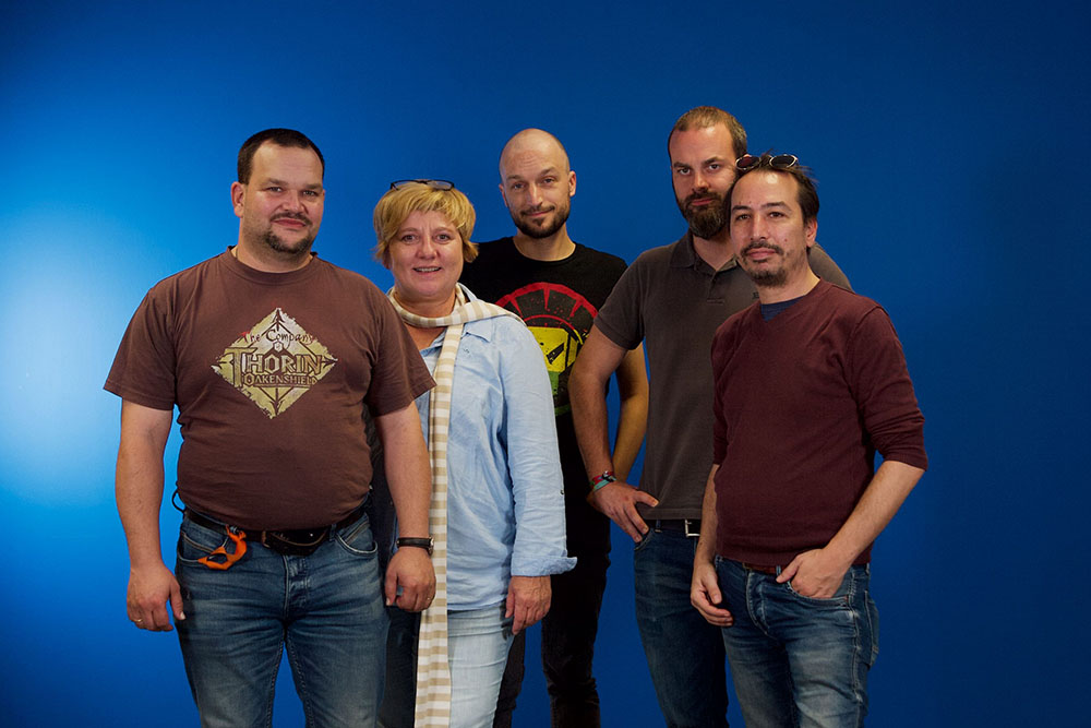 Gruppenfoto der Künstler vor einer blauen Leinwand