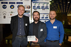 Gruppenbild der drei Studenten, die ein digitales Türschild zeigen.