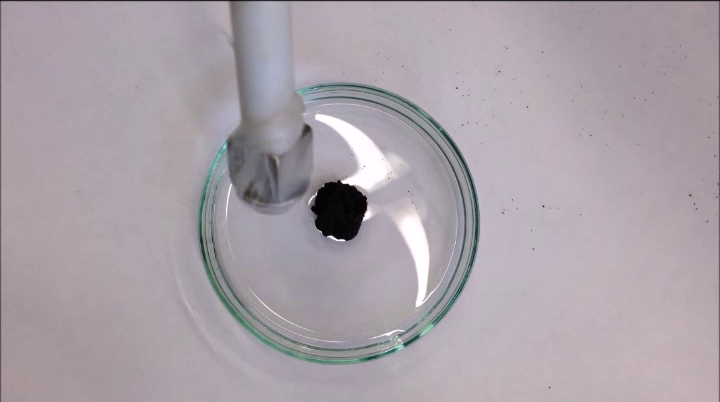 Petrischale mit Öl-Partikel-Gemisch und Magnet