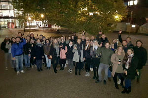 Ein Gruppenbild von vielen Menschen bei Nacht. Sie befinden sich gerade auf einer Kneipentour.