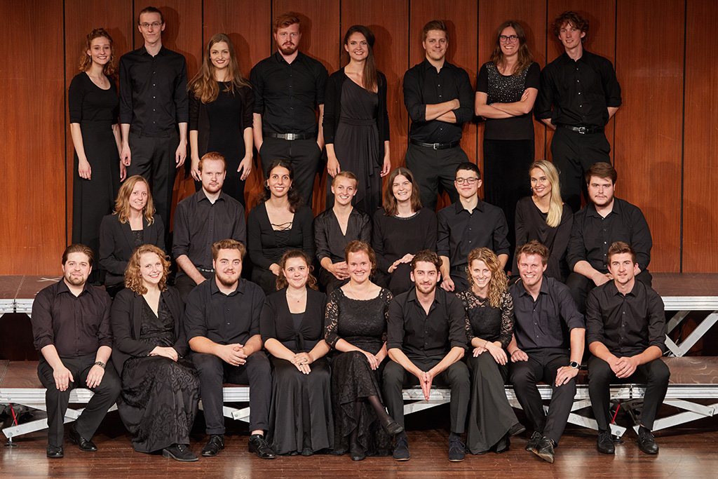 Gruppenbild des Chors: alle 25 Studierenden sind ganz in schwarz gekleidet.