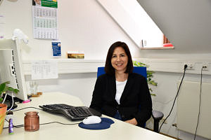 Portraitbild von Susanne Jäckle an ihrem Arbeitsplatz.