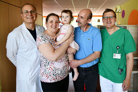 Prof. Dr. Robert Cesnjevar (l., Leiter der Kinderherzchirurgie) und Prof. Dr. Sven Dittrich (r., Leiter der Kinderkardiologie) freuen sich mit den Eltern über den glücklichen Ausgang dieses außergewöhnlich schweren Krankheitsverlaufs.