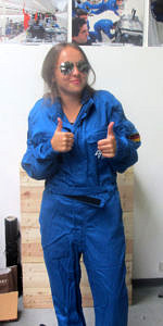 Ina Becker posiert für die Kamera und zeigt die Daumen nach oben: mit ihrem blauen Fluganzug und ihrer Sonnenbrille ähnelt sie einer Astronautin.