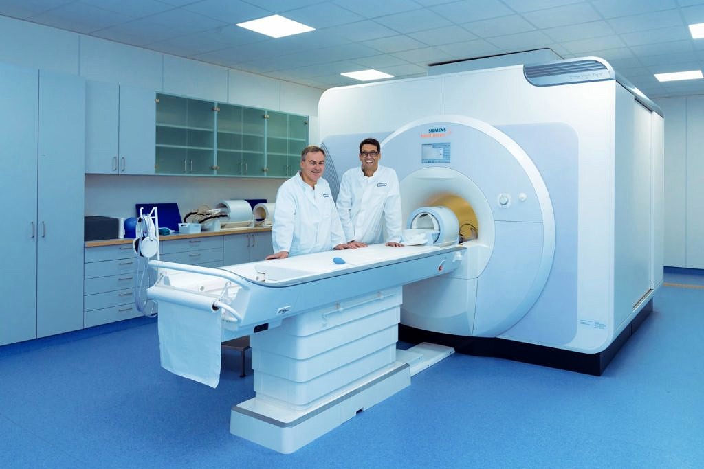 Dörfler and Uder in front of an MRI scanner at Uniklinium Erlangen