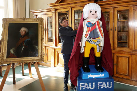 FAU-Präsident Joachim Hornegger enthüllt die PLAYMOBIL-Sonderfigur.