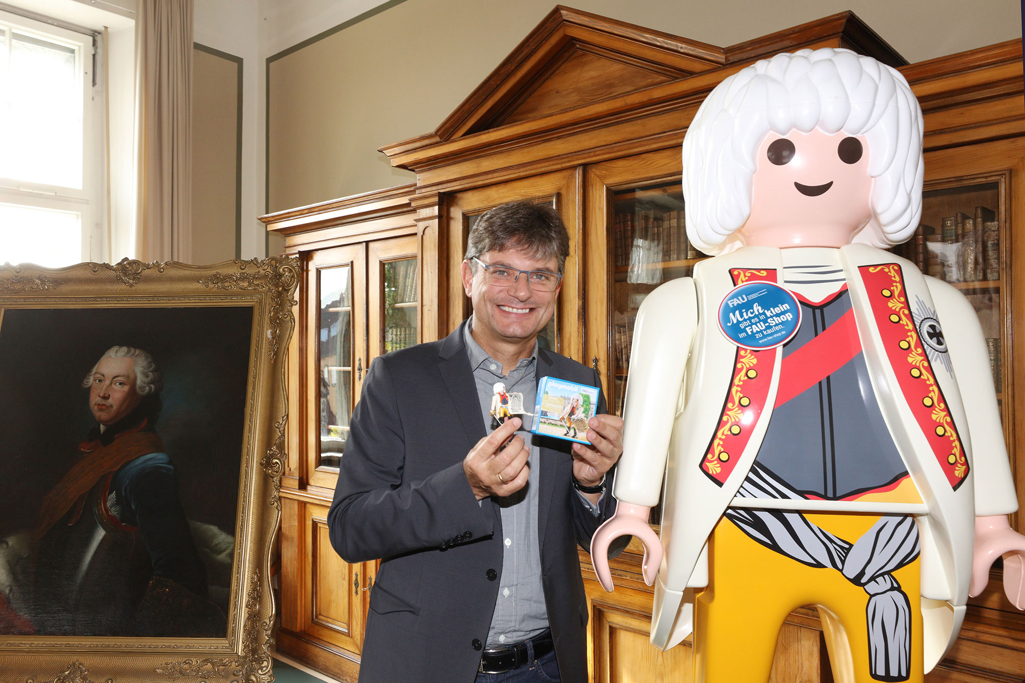 FAU President Prof. Dr. Joachim Hornegger presents the special edition PLAYMOBIL figure.