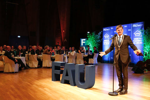 FAU-Präsident Prof. Dr. Joachim Hornegger begrüßt Gäste am Mikrofon.