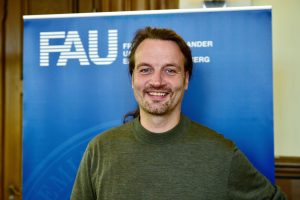 Porträt Kristian Franze vor FAU-Roll-Up