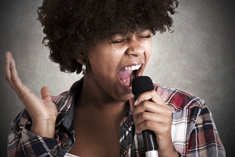 Eine Musikerin singt in ein Mikrofon.
