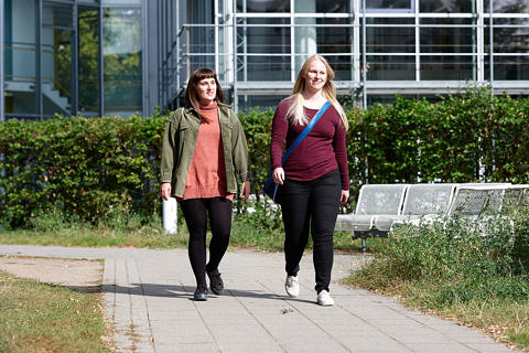 Zwei Studentinnen laufen nebeneinander.