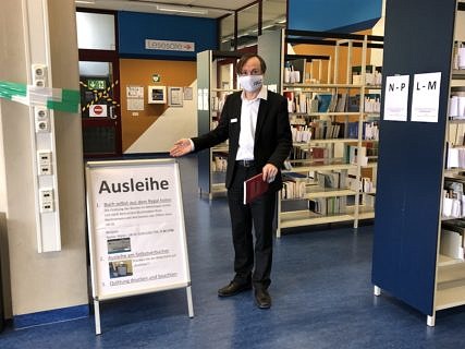 Mann mit Maske in der Hauptbibliothek