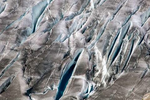Blick von oben auf Gletscher mit Schmelzwasser