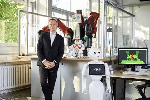 Prof. Dr. Jörg Franke vor verschiedenen Service-Robotern: Baxter, Pepper und Nao