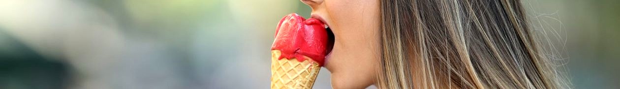 Frau verzieht schmerzvoll das Gesicht während sie ein Eis isst