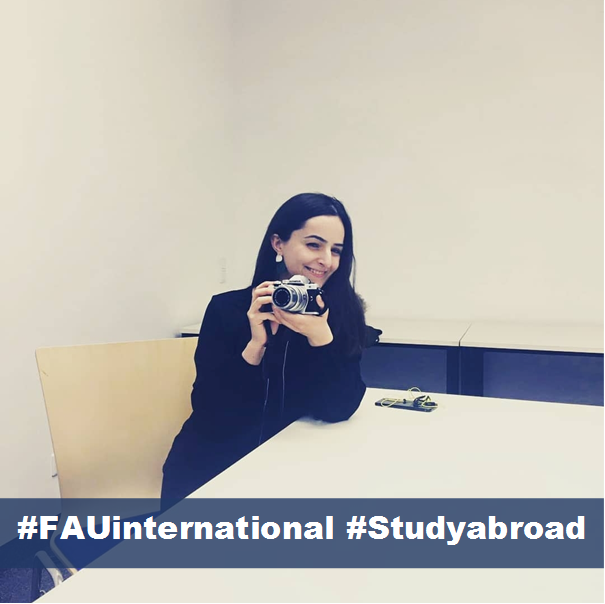 Portrait der Studentin Ani mit Fotokamera in der Hand, darunter steht #FAUinternational und #Studyabroad