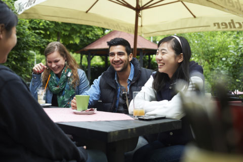 Studenten am Tisch in der Mensa.