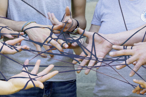 Hände halten Fäden zu Netz