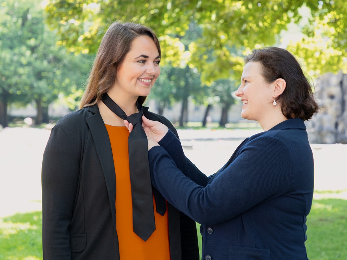 A woman ties the tie of another woman