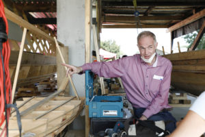 Prof. Dr. Boris Dreyer zeigt etwas am Römerboot.