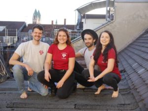 Vier junge Menschen hocken auf Dach