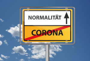 Straßenschild zeigt das Wort Corona durchgestrichen und das Wort Normalität mit einem Pfeil nach oben