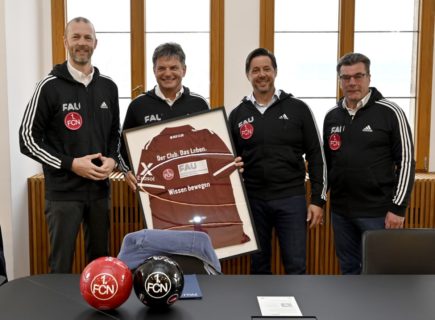 Gruppenfoto mit eingerahmtem Fußballtrikot