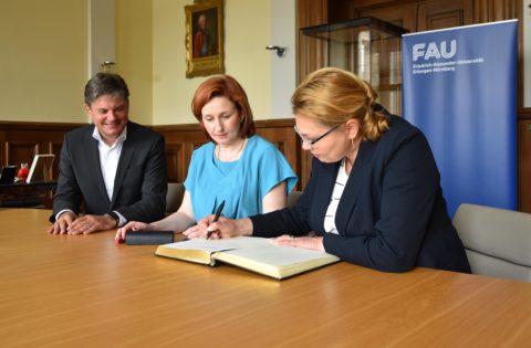 Prof. Dr. Kseniia Smyrnova, Vizepräsidentin Education (International Affairs), und Prof. Dr. Ganna Tolstanova, Vizepräsidentin Research (m.) trugen sich im Beisein von FAU-Präsident Prof. Dr. Hornegger in das Goldene Buch der FAU ein. (Foto: FAU/Boris Mijat)