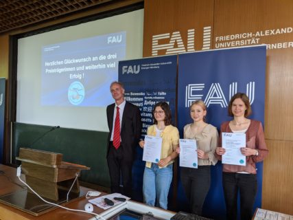 Gruppenfoto zeigt Schülerinnen mit Urkunden vor FAU-Bannern und Prof. Dr. Boris Dreyer