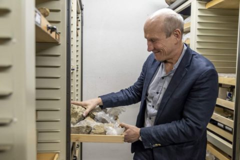 Wolfgang Kießling an Regal vor Schublade mit Steinen