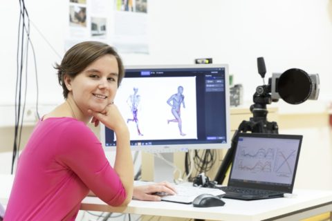 Prof. Dr. Anne Koelewijn vor Bildschirm der Mensch und Skelett in Bewegung zeigt