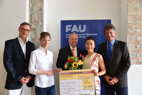 Hans-Georg Geis und Xue Hong Dong-Geis (3. und 4. v.l.) übergeben den symbolischen Scheck an Prof. Dr. Christian Mardin und PD Dr. Dr. Bettina Hohberger (v.l.) sowie FAU-Präsident Prof. Dr. Joachim Hornegger.