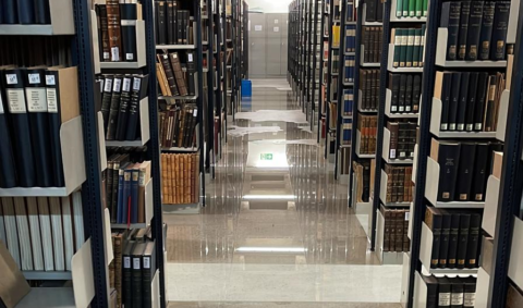 Wasser auf dem Boden zwischen Bücherregalen