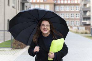 Yasmine M'Hirsi Doktorandin Theoretische Physik mit Regenschrim draußen