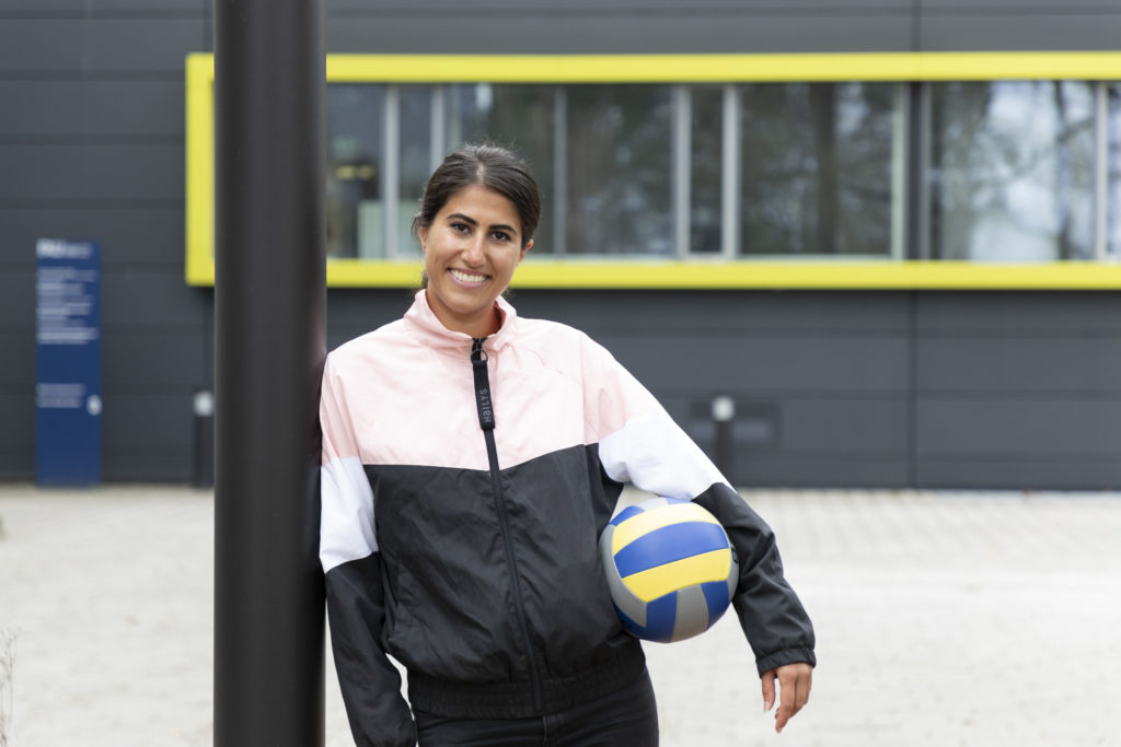 A woman holding a volley ball.