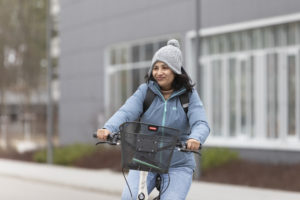 Eine Frau fährt in Winterkleidung Fahrrad.