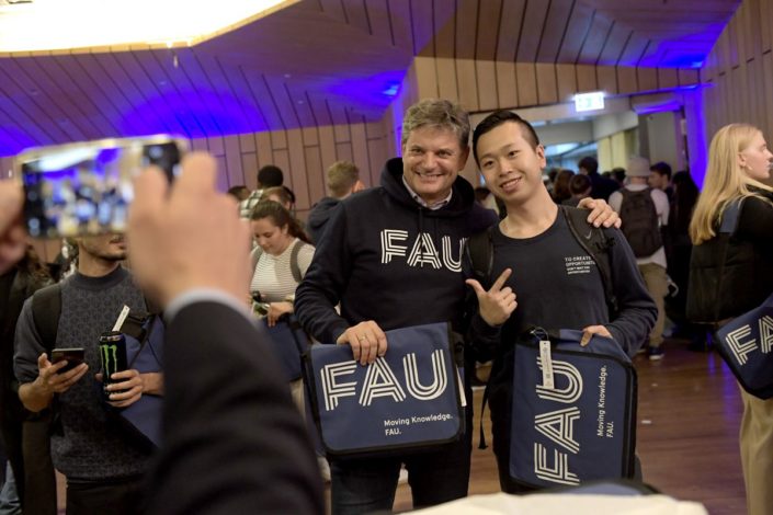 Präsident Joachim Hornegger mit Student und Erstsemestertasche